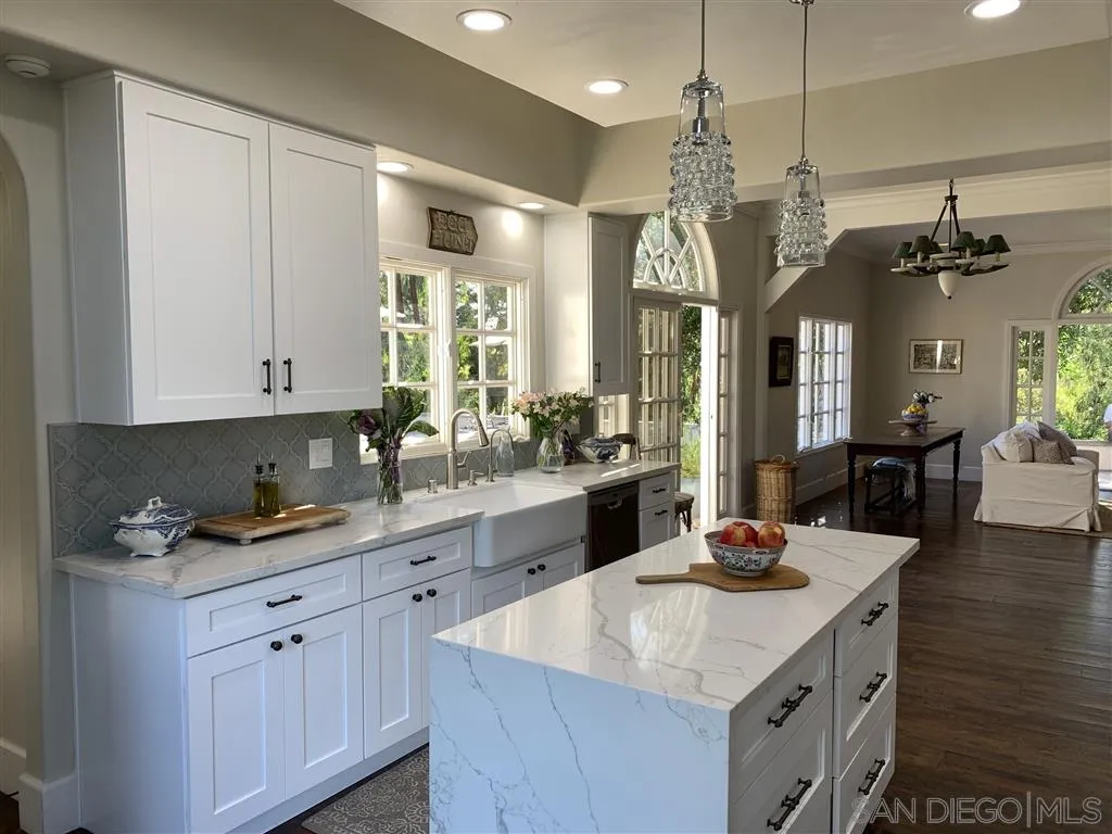 6645 Via Dos Valles Rancho Santa Fe, CA 92067 - Photo 7 of 20 a kitchen with a sink dishwasher and white cabinets with wooden floor