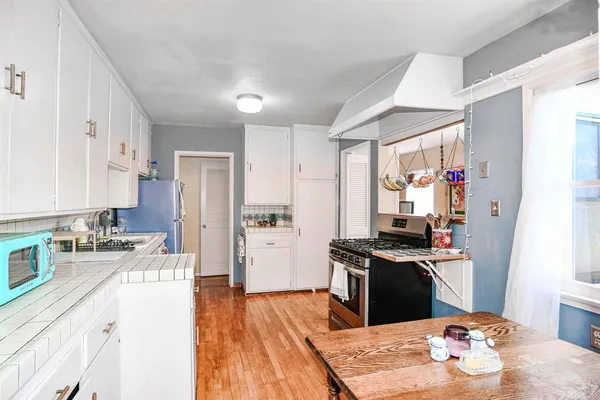 a kitchen with stainless steel appliances kitchen island granite countertop a sink stove and refrigerator