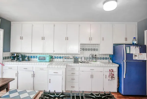 a kitchen with stainless steel appliances a stove a sink and white cabinets