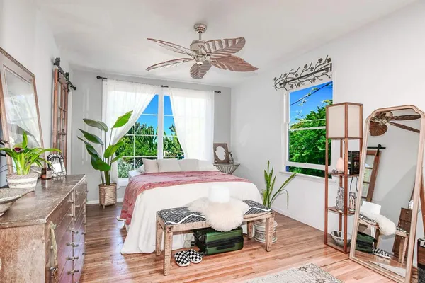 a dining room with furniture potted plants and wooden floor