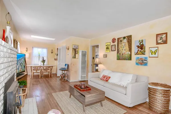 a living room with furniture and a dining table with wooden floor