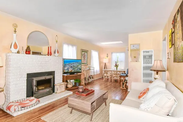a living room with furniture a fireplace and a large window with garden view