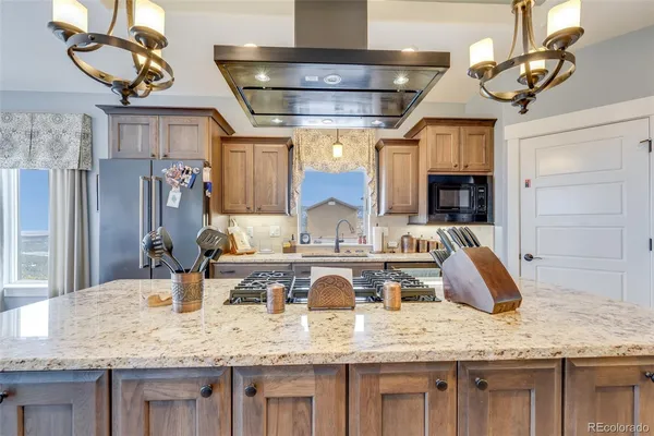 a large kitchen with stainless steel appliances and a wooden floor