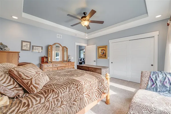 a spacious bedroom with a bed and a chandelier
