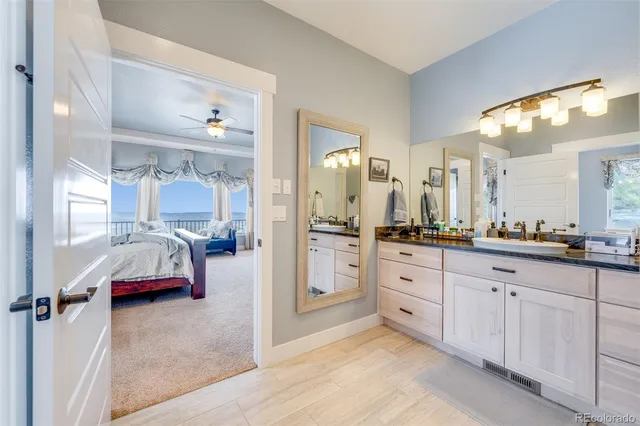 a bathroom with a granite countertop sink mirror vanity and toilet