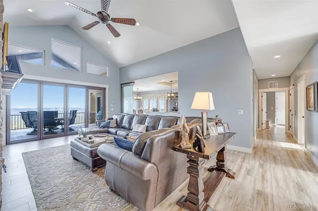 a living room with a dining table wooden floor and a fireplace