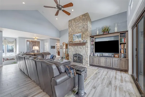a kitchen with stainless steel appliances kitchen island granite countertop a refrigerator a sink dishwasher and a stove with wooden floor