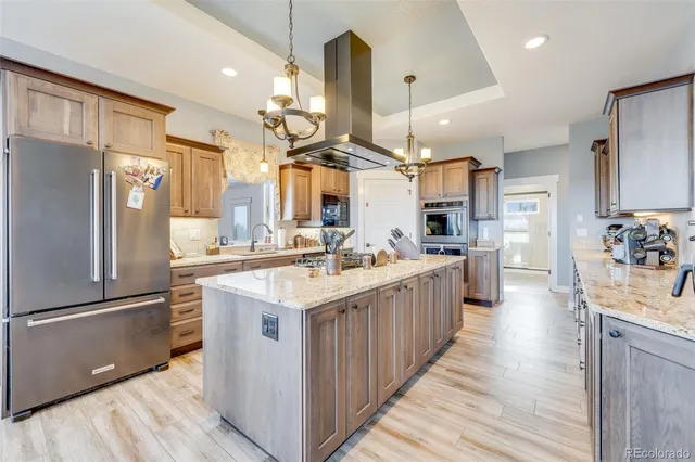 a large kitchen with stainless steel appliances granite countertop a stove oven and a refrigerator
