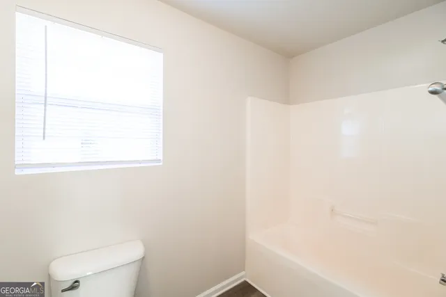 a white toilet sitting next to a window
