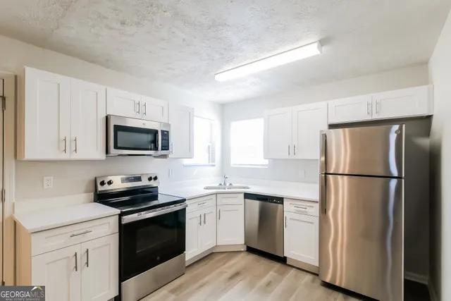 a kitchen with white cabinets and white appliances
