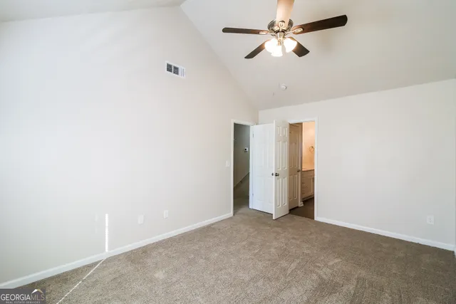 a view of a room with a ceiling fan and a window