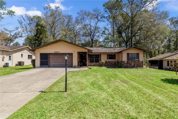 a front view of a house with a garden and yard