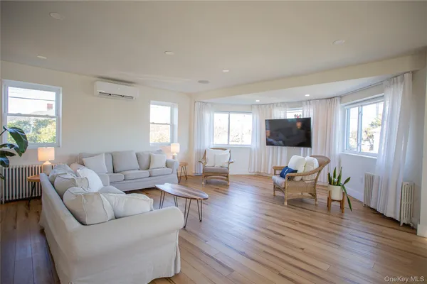 a living room with furniture flat screen tv and wooden floor