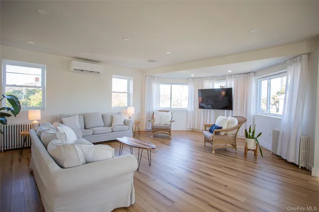 a living room with furniture flat screen tv and wooden floor