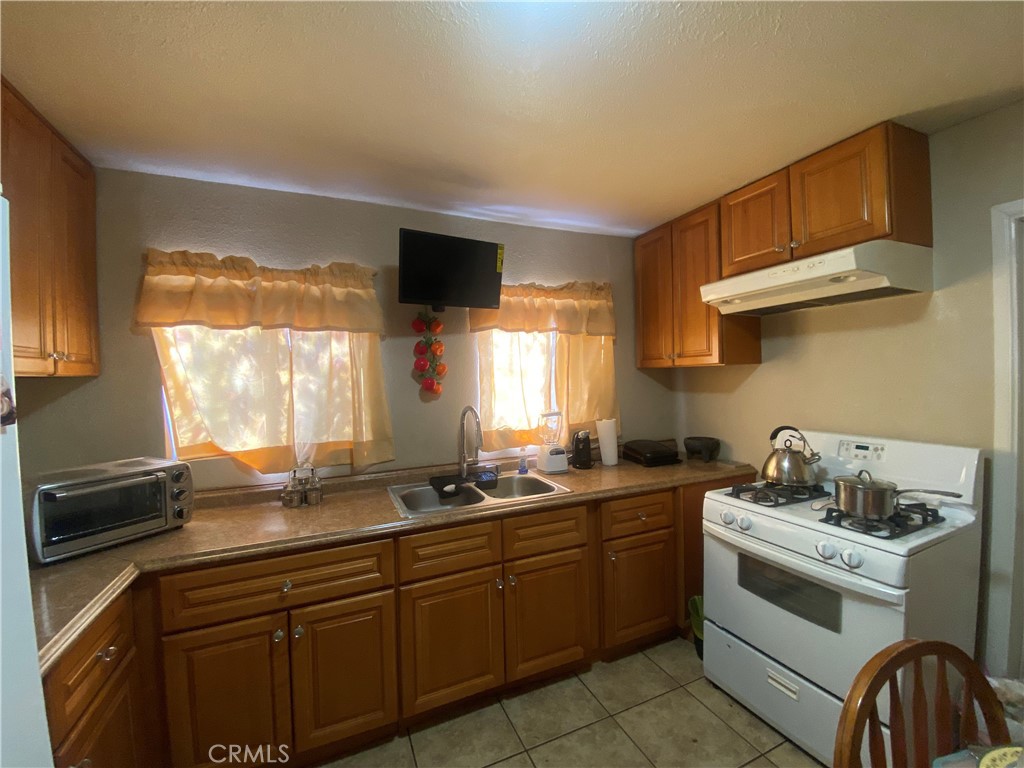 12065 Aztec Lane Adelanto, CA 92301 - Photo 42 of 64 a kitchen with a sink stove and cabinets