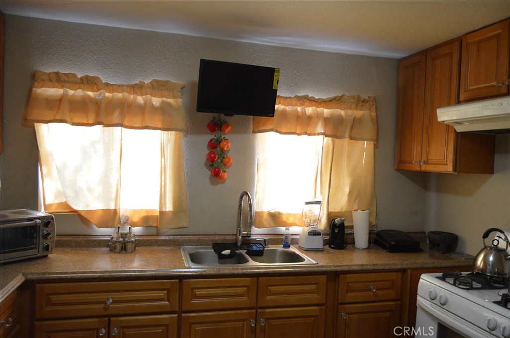 12065 Aztec Lane Adelanto, CA 92301 - Photo 46 of 64 a kitchen with a sink and a stove