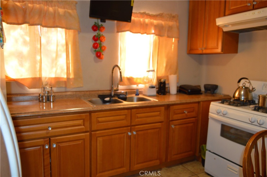 12065 Aztec Lane Adelanto, CA 92301 - Photo 47 of 64 a kitchen with a sink cabinets and a window