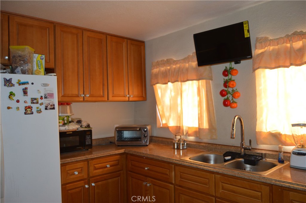 12065 Aztec Lane Adelanto, CA 92301 - Photo 48 of 64 a kitchen with stainless steel appliances a sink a stove and a window