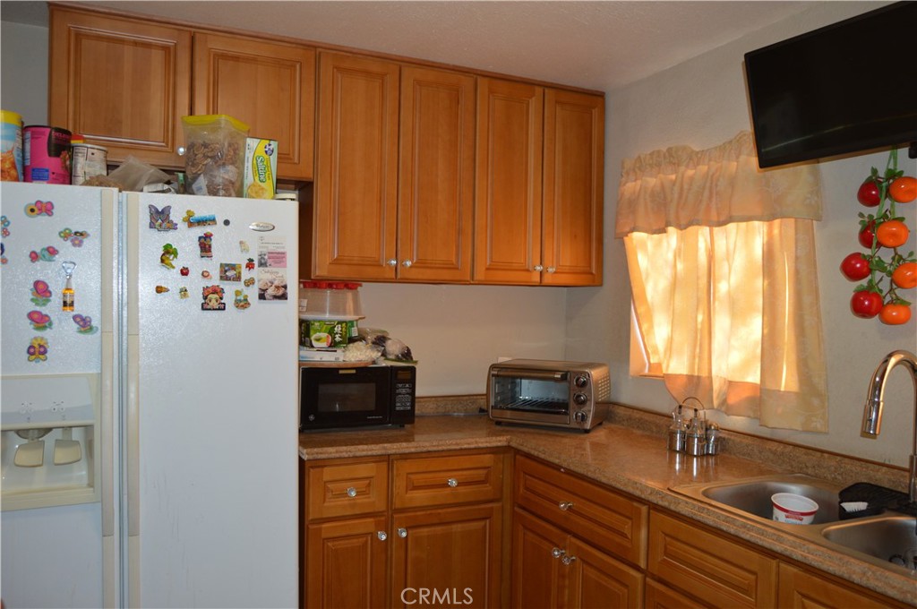 12065 Aztec Lane Adelanto, CA 92301 - Photo 50 of 64 a kitchen with stainless steel appliances granite countertop a refrigerator and a sink