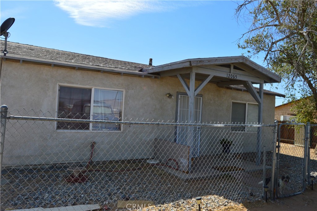 12065 Aztec Lane Adelanto, CA 92301 - Photo 7 of 64 a view of a small house with wooden fence