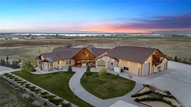 an aerial view of a house with outdoor space lake view and a car parked on the roadside