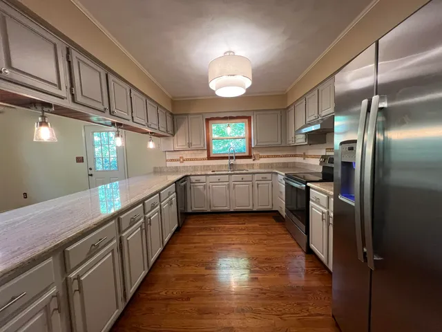 a large kitchen with stainless steel appliances lots of counter top space