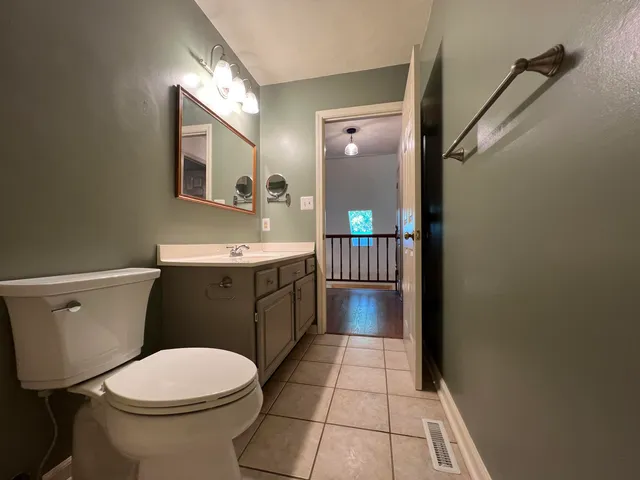 a bathroom with a toilet a sink and mirror