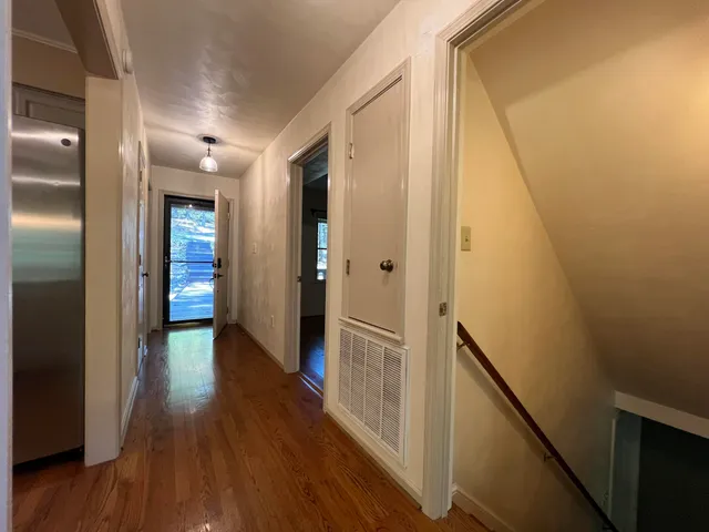 a view of a hallway with wooden floor