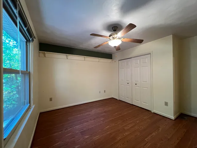 a view of a big room with wooden floor and a ceiling fan