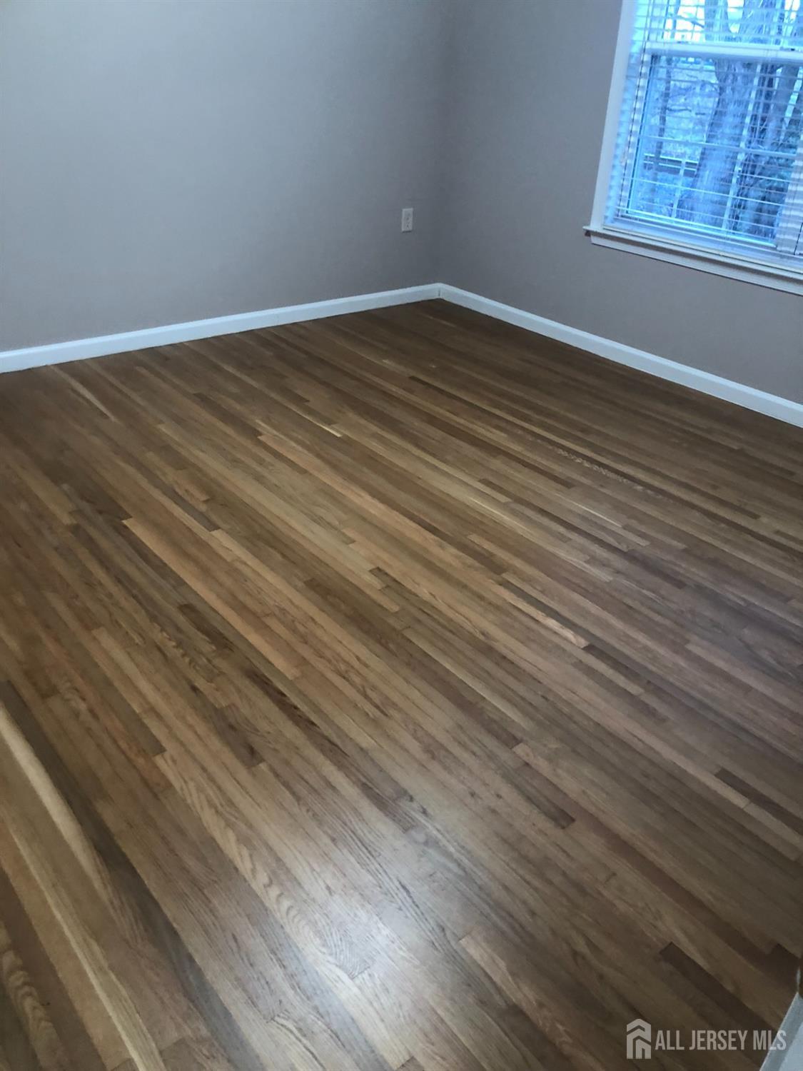 566 Cliff Road, Unit C Sewaren, NJ 07077 - Photo 12 of 14 a view of an empty room with wooden floor and a window