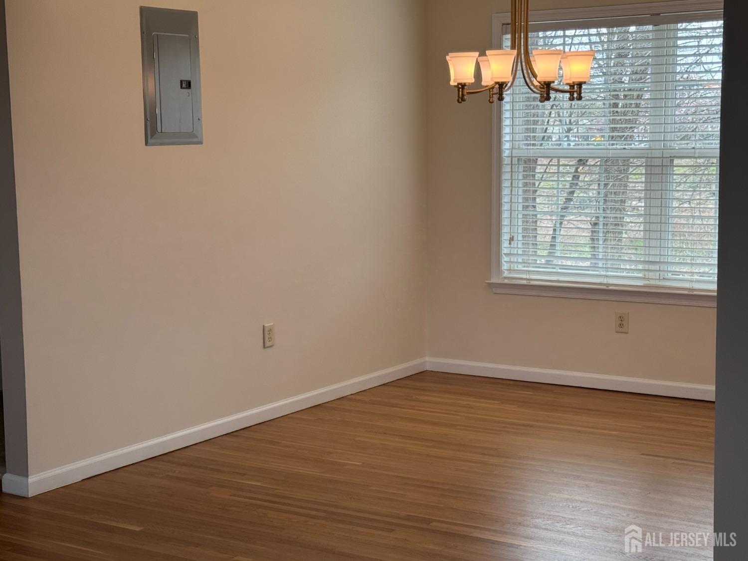 566 Cliff Road, Unit C Sewaren, NJ 07077 - Photo 7 of 14 an empty room with wooden floor and windows