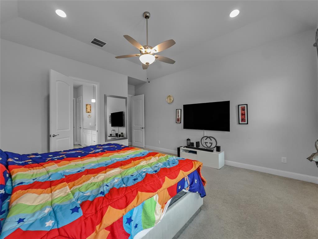 116 Chaco Drive Forney, TX 75126 - Photo 19 of 27 a bedroom with a bed and a flat screen tv