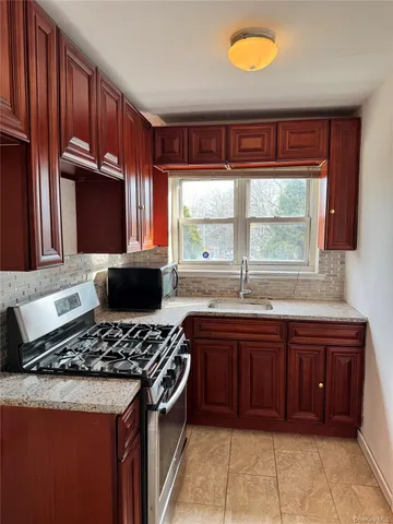 a kitchen with stainless steel appliances granite countertop wooden cabinets a stove and a sink