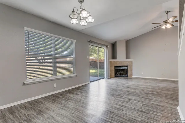 a view of a livingroom with a fireplace window and wooden floor