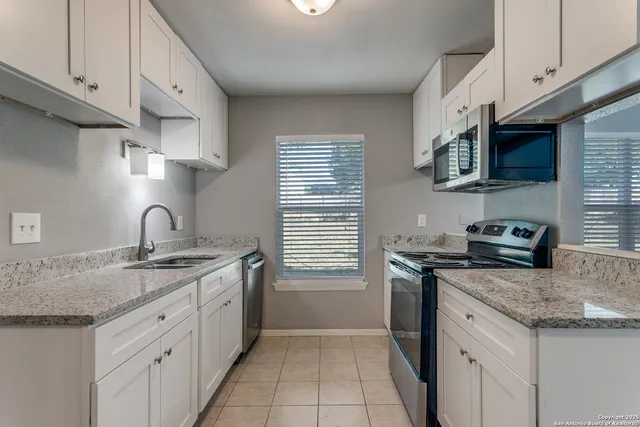 a kitchen with stainless steel appliances granite countertop a sink stove and cabinets