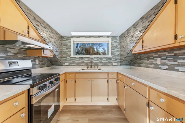 a kitchen with stainless steel appliances granite countertop a sink stove and cabinets