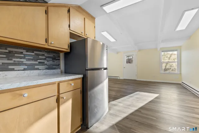 a kitchen with granite countertop a refrigerator and a stove top oven