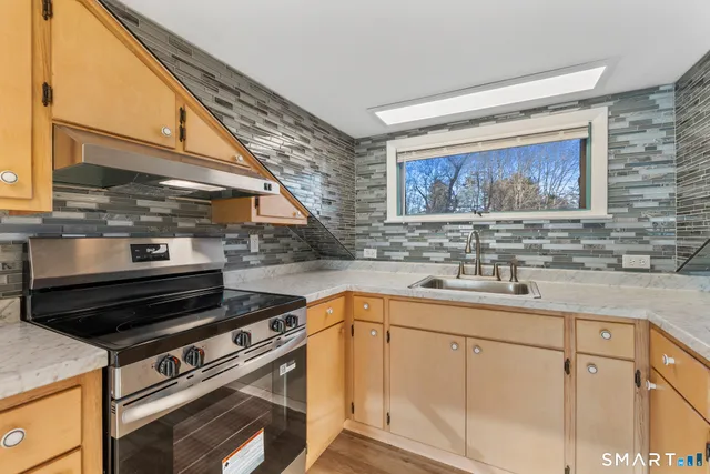 a kitchen with stainless steel appliances granite countertop a sink stove and cabinets