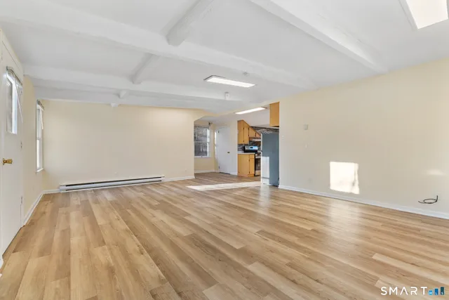 a view of empty room with wooden floor
