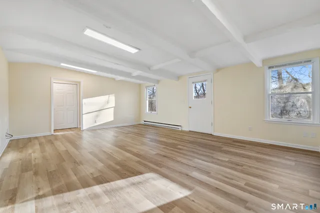 a view of empty room with wooden floor
