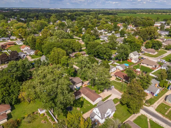an aerial view of residential houses with outdoor space and trees