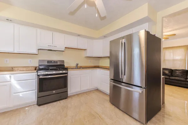 a kitchen with a refrigerator stainless steel appliances wooden floor and cabinets