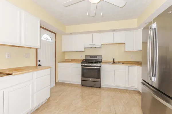 a kitchen with a refrigerator stove and white cabinets