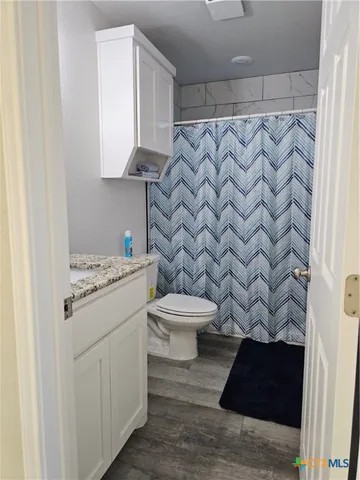a bathroom with a granite countertop bathtub and a toilet