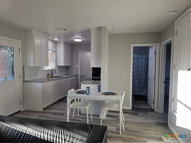 a kitchen with a dining table chairs and refrigerator