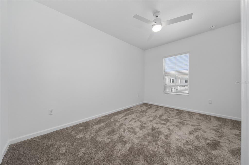 2587 Skyline Loop Kissimmee, FL 34758 - Photo 11 of 27 an empty room with a ceiling fan and a window