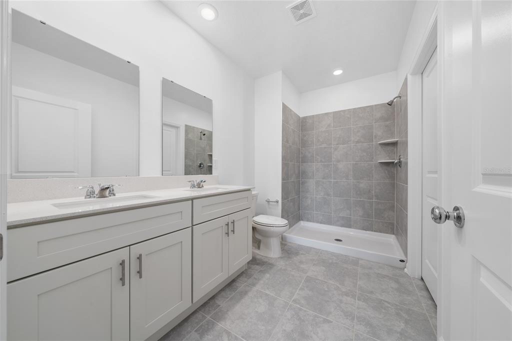 2587 Skyline Loop Kissimmee, FL 34758 - Photo 20 of 27 a bathroom with a double vanity sink toilet and shower