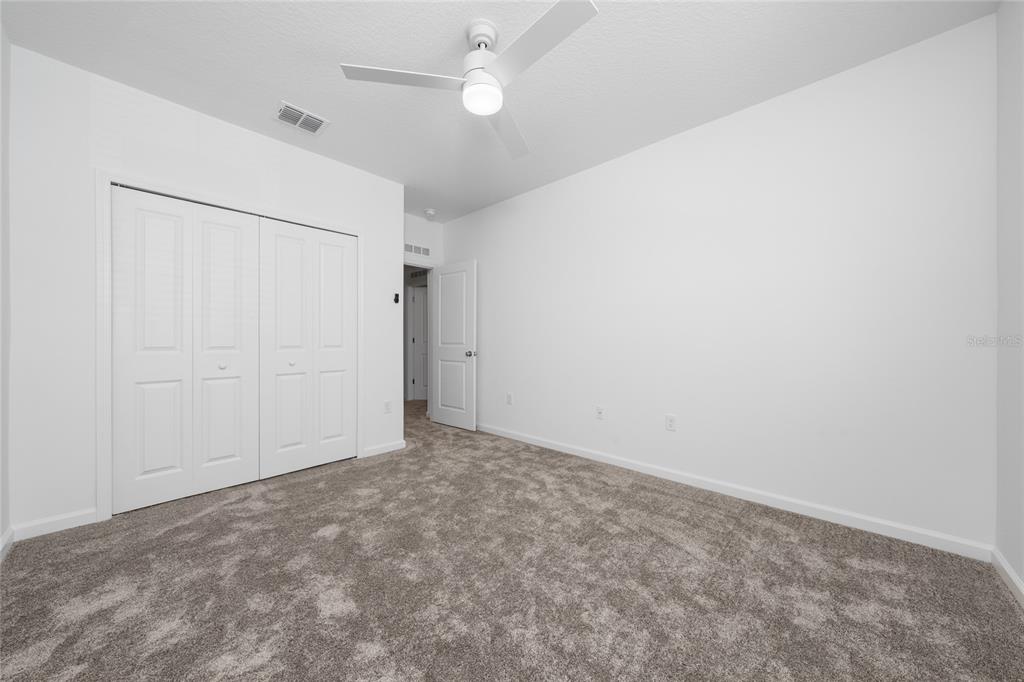 2587 Skyline Loop Kissimmee, FL 34758 - Photo 22 of 27 an empty room with a ceiling fan and a window