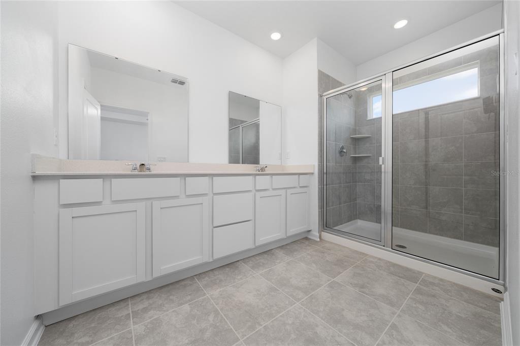2587 Skyline Loop Kissimmee, FL 34758 - Photo 23 of 27 a spacious bathroom with a shower sink and mirror