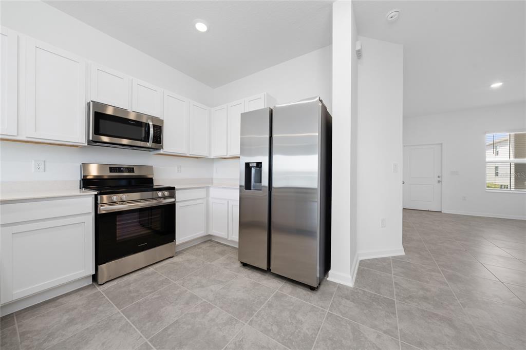 2587 Skyline Loop Kissimmee, FL 34758 - Photo 7 of 27 a kitchen with stainless steel appliances granite countertop a refrigerator a stove and a sink